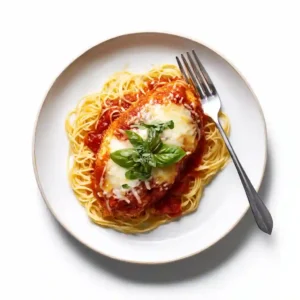 Overhead shot of slow cooker chicken parmesan recipe card photo with pasta and basil garnish